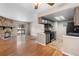 Open-concept living area featuring a stone fireplace, hardwood floors, and seamless kitchen access at 4400 S Quebec St # 108L, Denver, CO 80237