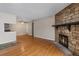 Inviting living room featuring a stone fireplace, open floorplan, and hardwood floors at 4400 S Quebec St # 108L, Denver, CO 80237