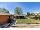 Well-maintained backyard with a covered patio, manicured lawn, and stone landscaping at 4953 W 61St Ave, Arvada, CO 80003