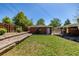 Manicured backyard featuring a lush lawn, raised garden beds, and covered patio at 4953 W 61St Ave, Arvada, CO 80003