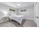 This cozy bedroom offers natural light with a light colored walls and floors and a bedside table at 4953 W 61St Ave, Arvada, CO 80003