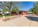 View of the charming red brick home, detached garage, and long driveway at 4953 W 61St Ave, Arvada, CO 80003