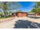 View of the charming red brick home, detached garage, and long concrete driveway at 4953 W 61St Ave, Arvada, CO 80003