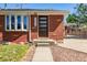 Brick home's front porch with a modern front door and manicured lawn at 4953 W 61St Ave, Arvada, CO 80003