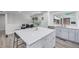 Bright kitchen featuring a large island with seating and modern appliances adjacent to the dining room at 4953 W 61St Ave, Arvada, CO 80003