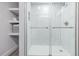 Bright shower with sleek glass doors, white marble tiles, and built-in shelves at 4953 W 61St Ave, Arvada, CO 80003