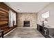 Comfortable living room with a wood-paneled wall, brick fireplace, and modern entertainment center at 4416 E 93Rd Pl, Thornton, CO 80229