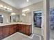 Well-lit bathroom with double sinks, granite countertops, and a large mirror with dressing area at 5474 Espana St, Denver, CO 80249