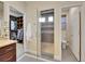 A modern bathroom with a glass shower, a closet area, and tiled floors at 5474 Espana St, Denver, CO 80249
