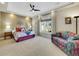 Spacious bedroom featuring a modern ceiling fan, a large window, and a cozy sitting area at 5474 Espana St, Denver, CO 80249