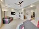 Spacious bedroom with a ceiling fan, flat-screen TV, and view into the bathroom area at 5474 Espana St, Denver, CO 80249