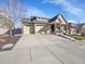 Charming home featuring a three car garage, stone accents, and a well maintained lawn at 5474 Espana St, Denver, CO 80249