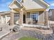 Inviting front porch with stone pillars and seating area at 5474 Espana St, Denver, CO 80249