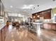 Open-concept kitchen with granite countertops, dark wood cabinets and hardwood flooring at 5474 Espana St, Denver, CO 80249