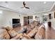 Open-concept living room featuring kitchen, dining room, ceiling fan, and hardwood floors at 5474 Espana St, Denver, CO 80249
