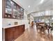 Open-concept living room features dining room, hardwood floors and decorative glass cabinet at 5474 Espana St, Denver, CO 80249