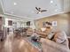 Open-concept living room featuring kitchen, dining room, ceiling fan, and hardwood floors at 5474 Espana St, Denver, CO 80249