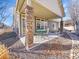 Covered patio space with stone pillars and an outdoor dining set for entertaining at 5474 Espana St, Denver, CO 80249