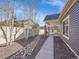 Landscaped backyard with a walkway leading to a covered patio at 5474 Espana St, Denver, CO 80249