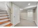 Finished basement space with stairs, neutral carpet, and a utility door at 4268 S Delaware St, Englewood, CO 80110