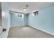 Cozy bedroom with light blue walls, carpeted floor, and natural light streaming through the window at 4268 S Delaware St, Englewood, CO 80110