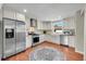 Modern kitchen with stainless steel appliances, white cabinets, and hardwood floors at 4268 S Delaware St, Englewood, CO 80110