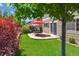 Charming backyard with a stone patio, outdoor seating, mature trees, and garden bed at 7342 S Mobile St, Aurora, CO 80016