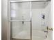 Bright bathroom featuring glass shower doors, built-in shelving, and tiled walls at 7342 S Mobile St, Aurora, CO 80016