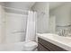Neutral bathroom featuring shower-tub combo, white shower curtain, and a modern dark vanity at 7342 S Mobile St, Aurora, CO 80016