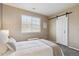 Cozy bedroom featuring a sliding barn door, and an abundance of natural light at 7342 S Mobile St, Aurora, CO 80016