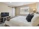Cozy bedroom with a queen bed, barn door, TV, and a window with blinds at 7342 S Mobile St, Aurora, CO 80016