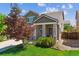 Inviting two-story home featuring a charming front porch and well-manicured lawn and beautiful landscaping at 7342 S Mobile St, Aurora, CO 80016