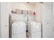Well-organized laundry room with washer, dryer, storage shelves and ironing board at 7342 S Mobile St, Aurora, CO 80016