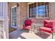 Inviting porch with comfortable seating, brickwork, and a decorative security door at 7342 S Mobile St, Aurora, CO 80016