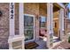 Inviting porch with comfortable seating, brickwork, and a decorative security door at 7342 S Mobile St, Aurora, CO 80016