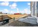 Spacious backyard with a wooden fence, concrete steps, and blue skies in a new community at 240 Lark Sparrow Way, Bennett, CO 80102