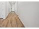 Bright hallway with wood-look floors leads to the front door, offering a glimpse of the home's modern design at 240 Lark Sparrow Way, Bennett, CO 80102