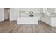 Clean and modern kitchen featuring white cabinets, a center island, and updated stainless-steel appliances for gourmet cooking at 240 Lark Sparrow Way, Bennett, CO 80102