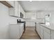 Modern white kitchen with stainless steel appliances, a center island, and ample countertop space for cooking at 240 Lark Sparrow Way, Bennett, CO 80102