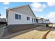 Rear exterior featuring white siding, large windows, and a patio door in a residential area at 240 Lark Sparrow Way, Bennett, CO 80102