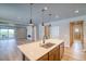 Modern kitchen with a center island, pendant lighting, stainless steel appliances, and wood floors at 39210 Anthony St, Elizabeth, CO 80107