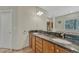 Bathroom featuring a dual sink vanity with granite countertop and wood cabinets, offering ample storage space at 4726 Pinon Dr, Elizabeth, CO 80107