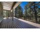 Inviting deck with wood flooring and wood railing, offering serene views of surrounding trees and ample outdoor living at 4726 Pinon Dr, Elizabeth, CO 80107