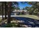 Exterior view of home with driveway, showcasing the well-maintained property and nestled among mature trees for privacy at 4726 Pinon Dr, Elizabeth, CO 80107