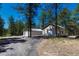 Home exterior with a driveway leading to multiple outbuildings including one with a garage door at 4726 Pinon Dr, Elizabeth, CO 80107