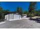 Home exterior featuring two outbuildings, one with a garage door and gravel surround at 4726 Pinon Dr, Elizabeth, CO 80107
