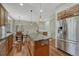 Modern kitchen with a central island, stainless steel appliances, wooden cabinetry, and a breakfast nook with a treed view at 4726 Pinon Dr, Elizabeth, CO 80107