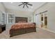 Main bedroom features an ensuite bathroom, ceiling fan, carpet, and large windows with treed views at 4726 Pinon Dr, Elizabeth, CO 80107