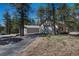 Detached garage and metal building with a driveway, surrounded by beautiful natural landscaping at 4726 Pinon Dr, Elizabeth, CO 80107