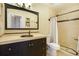 A stylish bathroom with a dark vanity, decorative mirror, and a tiled shower featuring a shower curtain at 482 Southpark Rd, Highlands Ranch, CO 80126
